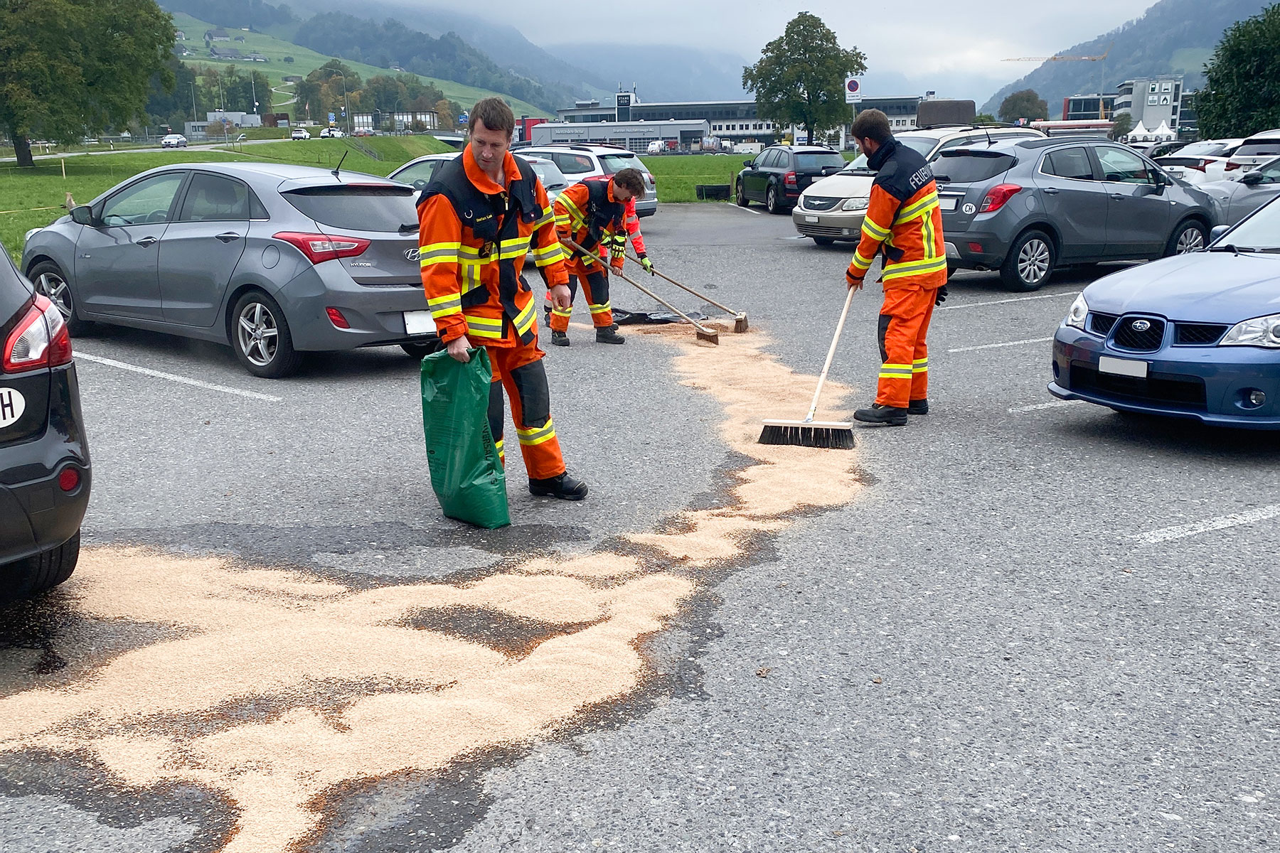 Aus einem parkierten Auto läuft Benzin aus, welches beseitigt werden muss.