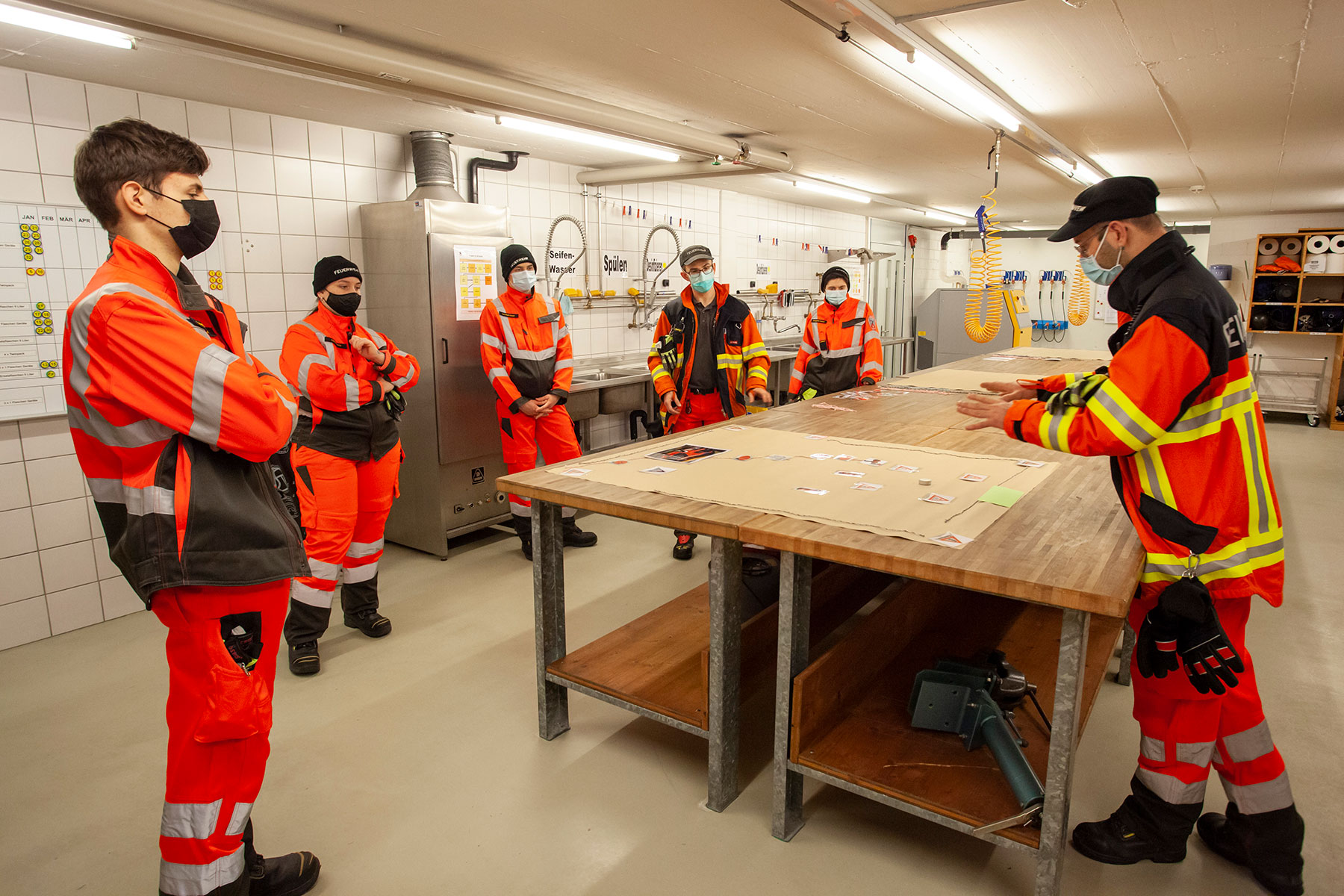 Die neu in die Feuerwehr Eingeteilten nehmen an einer Lektion über die Schadenplatzorganisation teil.