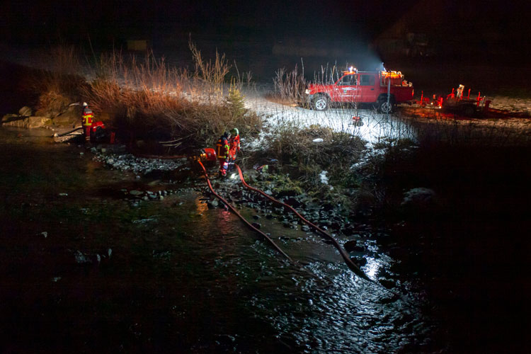 Mit Motorspritzen fördert die Feuerwehr Löschwasser aus der Aa.