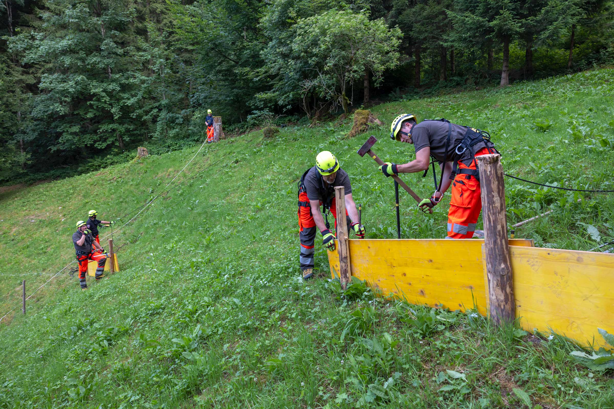 Mitglieder der ADL-Gruppe üben im Chälti Arbeitstechniken im Gelände, bei denen Personen und Material an Seilen gesichert werden.