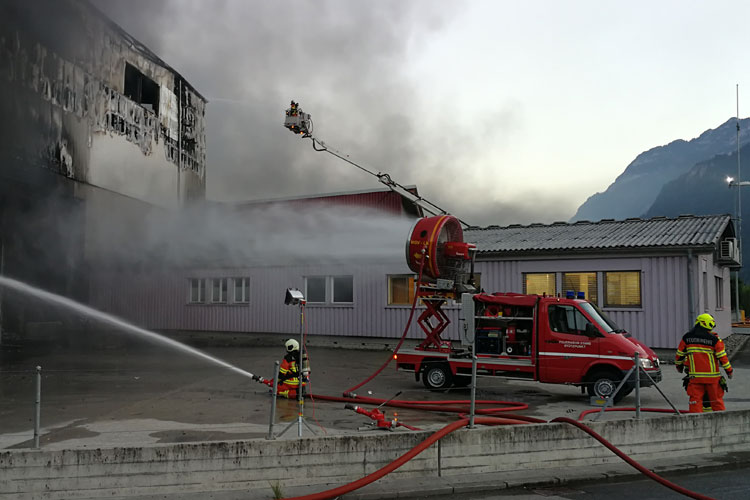 Beim Grossbrand einer Recycling- und Sporthalle in Altdorf unterstützt die Stützpunktfeuerwehr Stans die Löscharbeiten mit der Autodrehleiter und dem mobilen Grossventilator.
