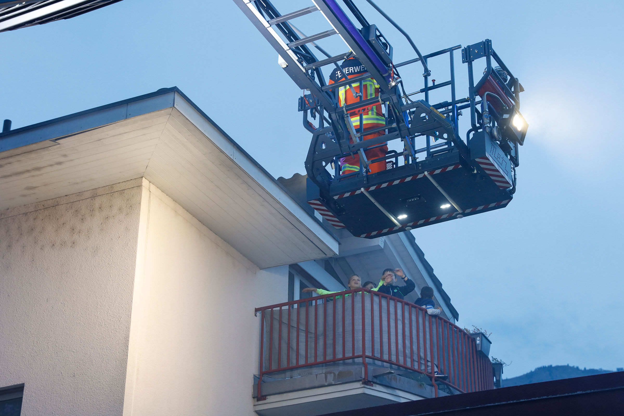 Die Besatzung der Autodrehleiter rettet die Kinder vom Balkon.