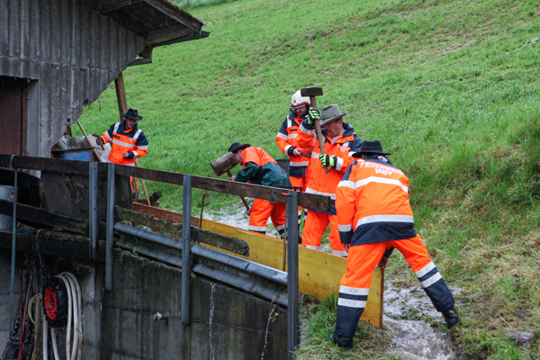 Zum Schutz eines Stalls setzt die Feuerwehr Bretter ein.