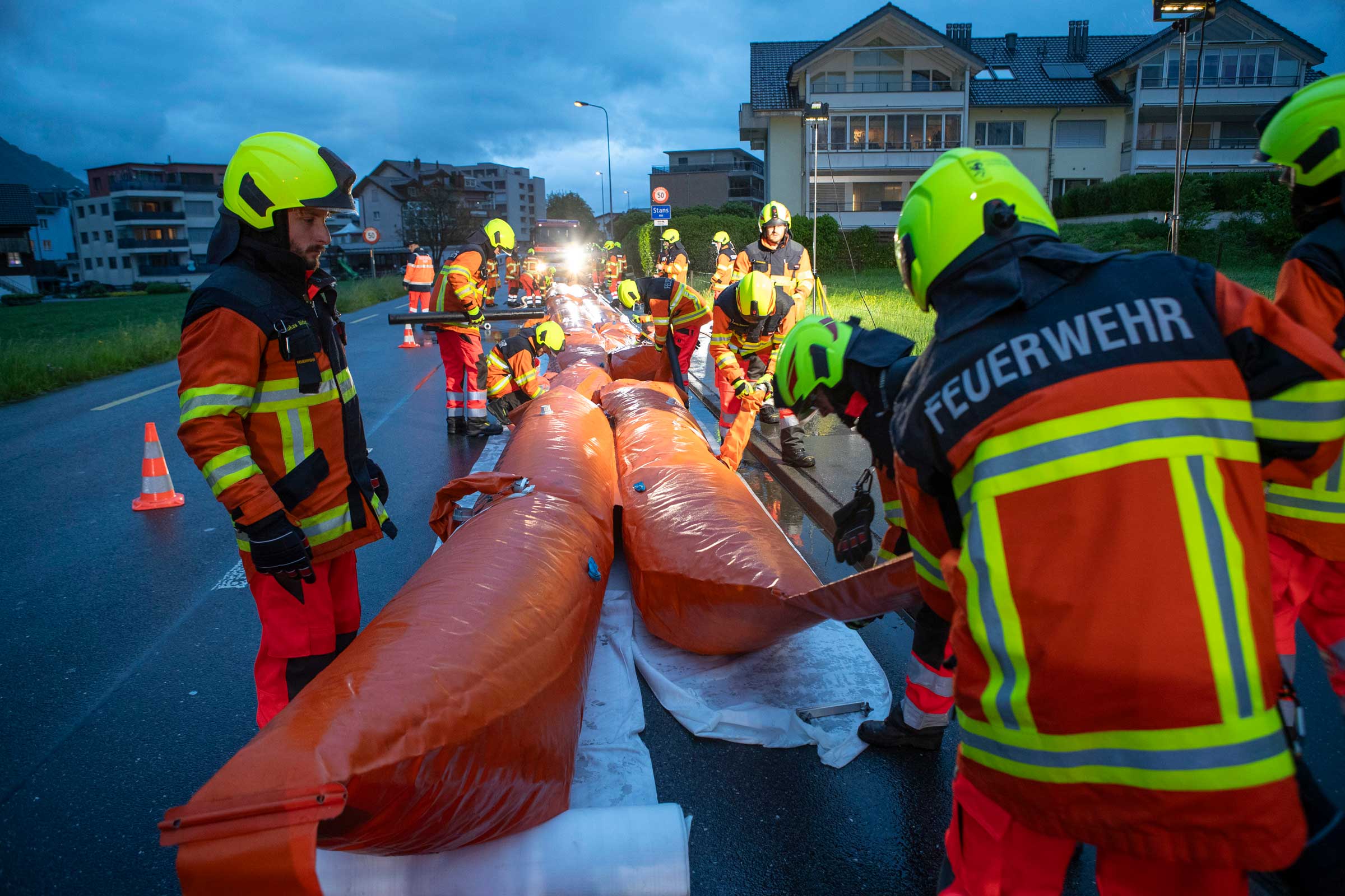 Der 2. Einsatzzug baut auf der Ennetmooserstrasse übungshalber Hochwassersperren auf.