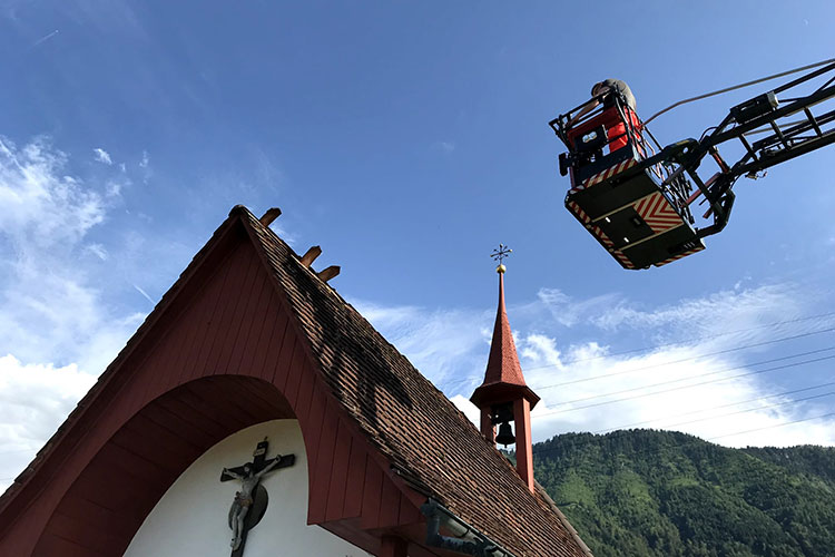Das Sonntagspikett richtet an der Knirikapelle ein paar Ziegel, die der Wind zerzaust hat.