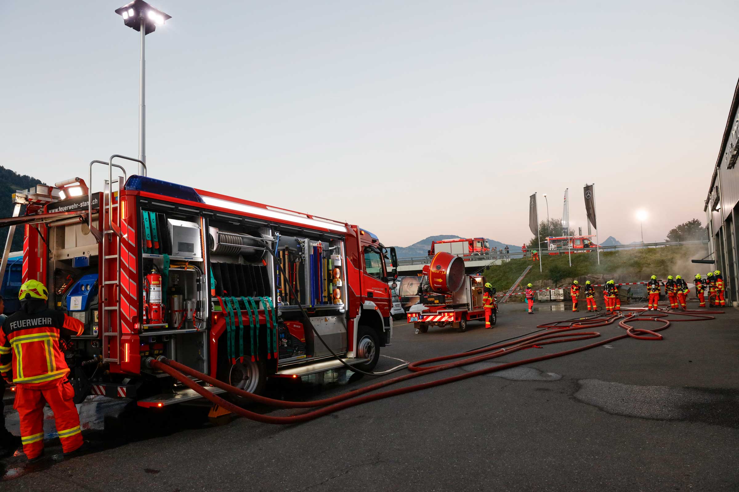 Beim brennenden Auto bauen die Einsatzzüge den dreifachen Brandschutz auf.