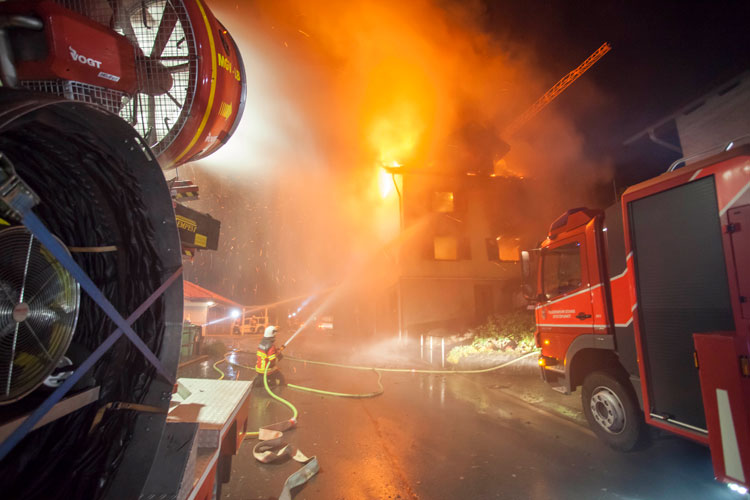 Der mobile Grossventilator MGV (links) schützt die Nachbarhäuser mit kühlenden Wassernebel.