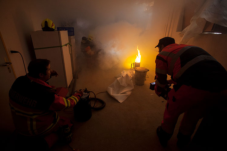 Kunstrauch, Scheinwerfer und Gasflamme simulieren einen Brand.