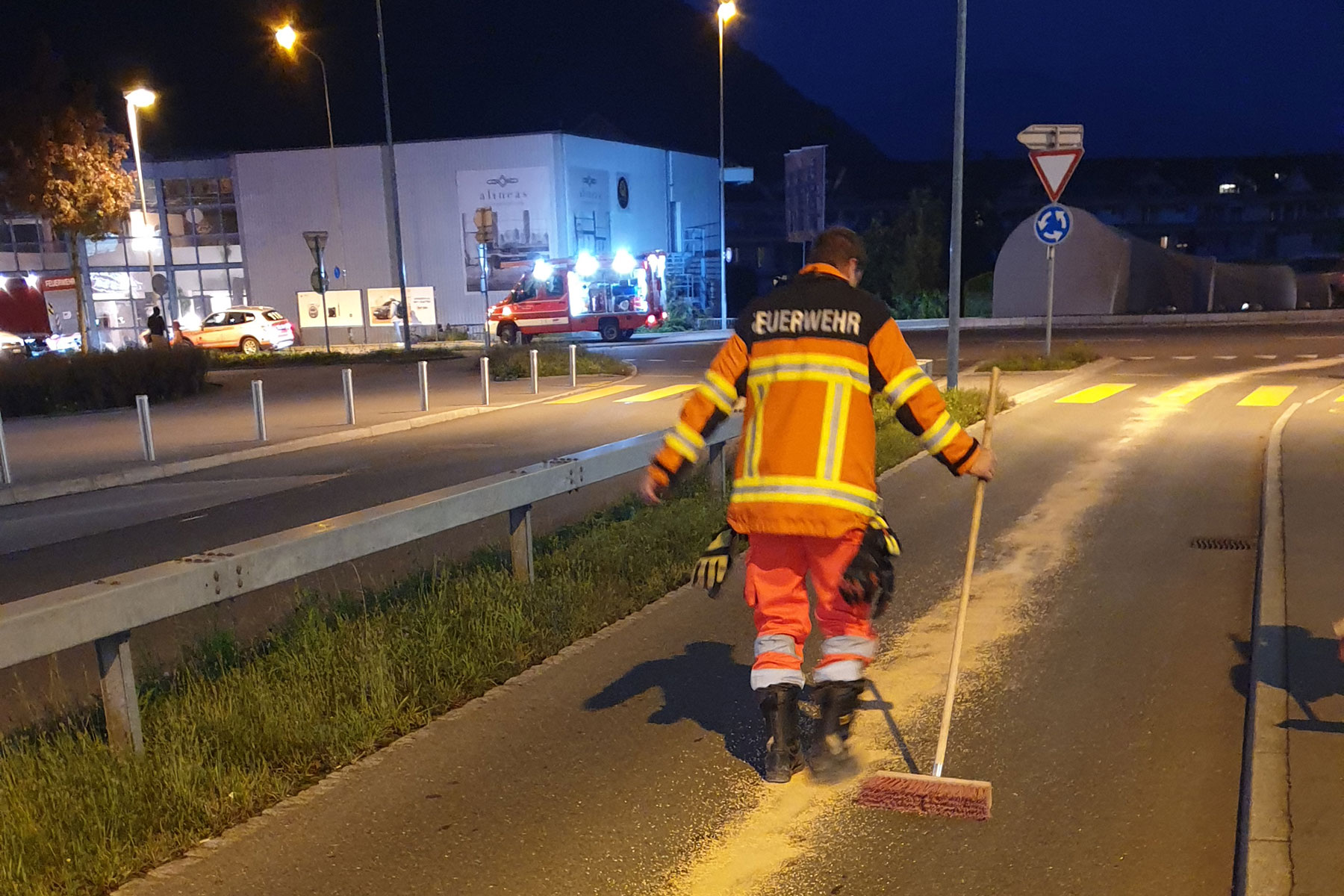 Durch ein Konferenzgespräch aufgeboten beseitigen Feuerwehrleute eine Ölspur auf der Bitzistrasse.