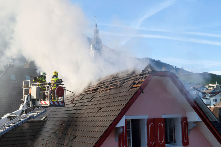 Die Stützpunktfeuerwehr Sarnen beginnt auf der Ostseite vom Hubrettungsfahrzeug aus, Ziegel zu entfernen.