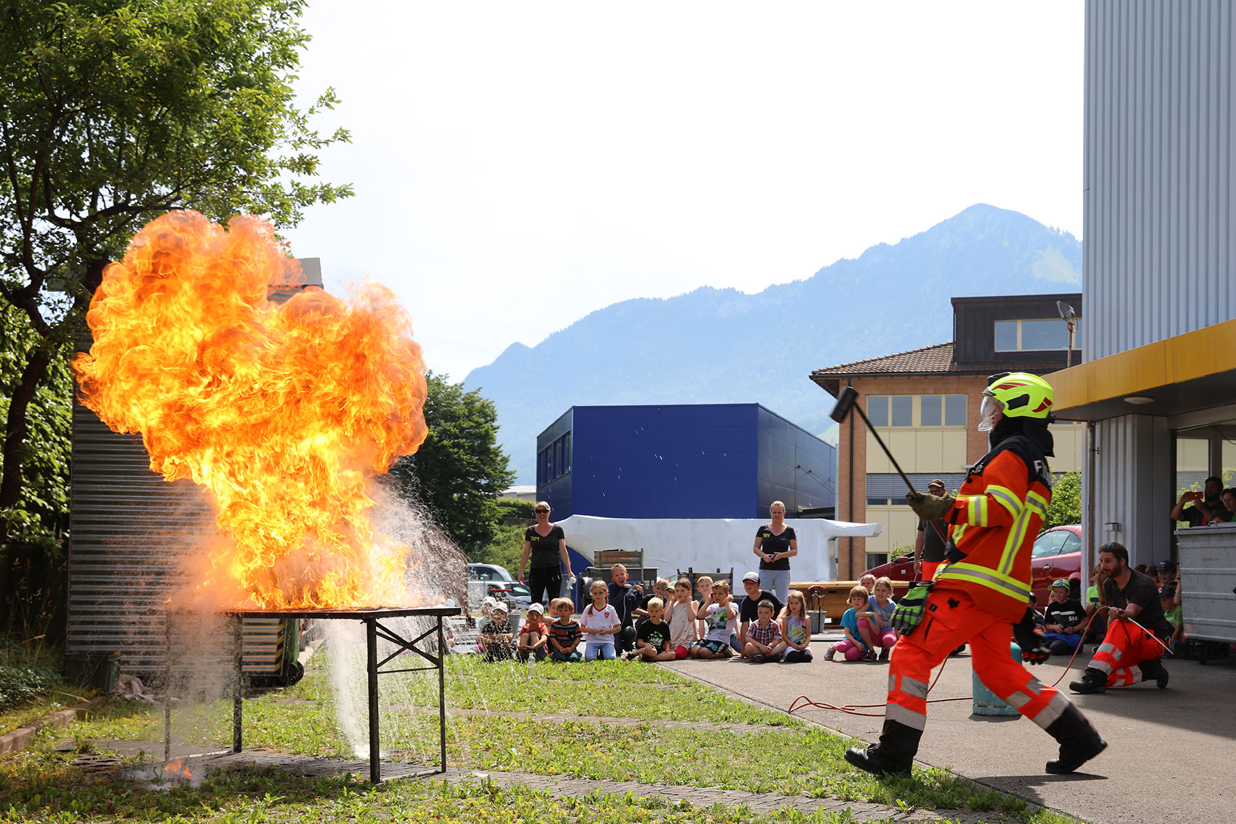 Kinder des Treffs aktiver Mütter besuchen die Feuerwehr und beobachten eine Löschdemonstration.