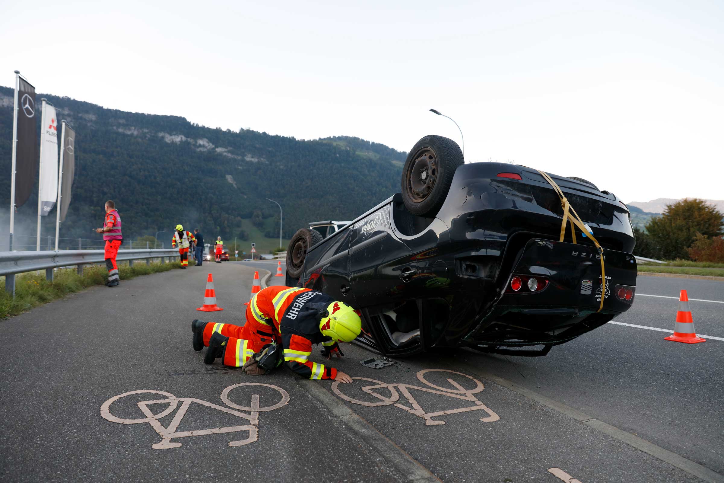 Dort wo die Fahrspur für Velos wäre, liegt ein Personenwagen auf dem Dach.
