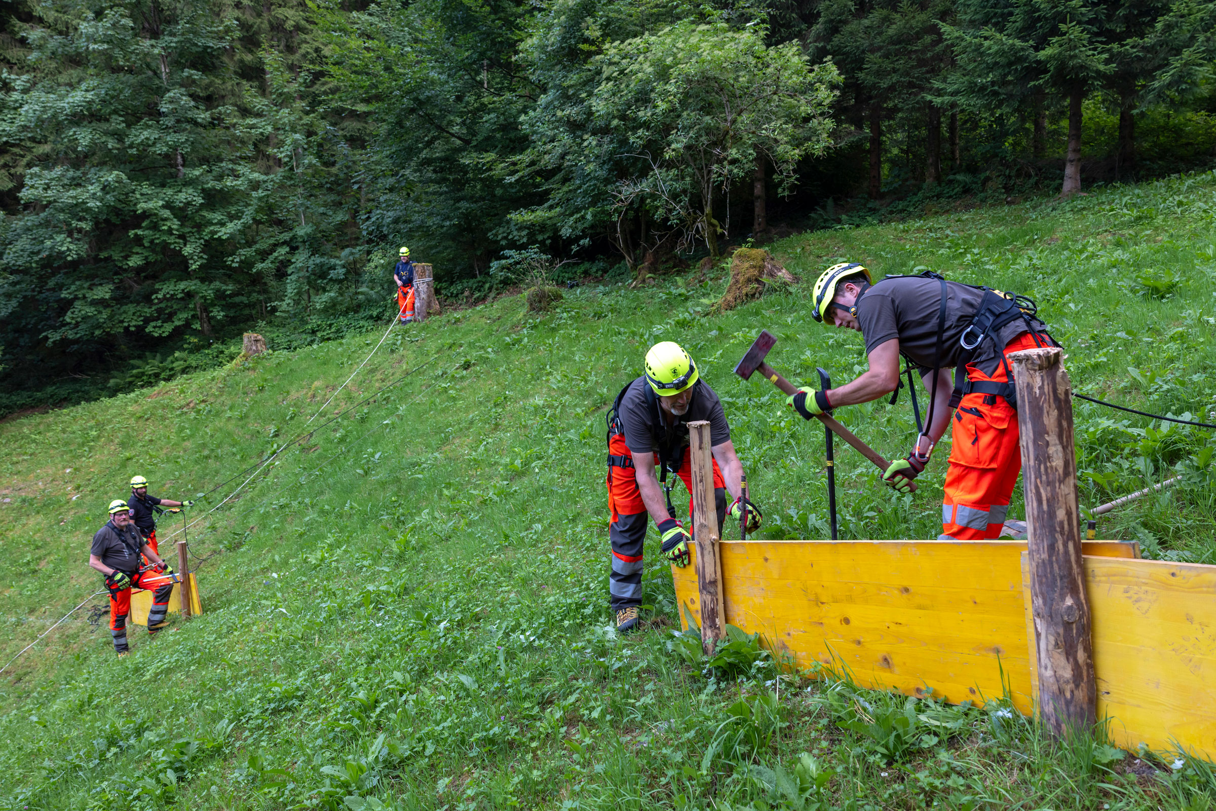 In Gruppen arbeiten die Feuerwehrleute an den Verbauungen.