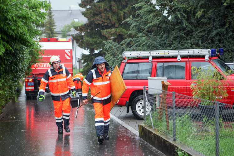 Nach starken Regenfällen stehen am Pfingstsamstag beide Einsatzzüge im Einsatz. Sie kontrollierten Bäche, reinigen Schwemmholzrechen, plazieren Sandsäcke und sperren exponierte Wege ab. Wo Gebäude gefährdet oder Räume überflutet sind, kommen Pumpen zum Einsatz.