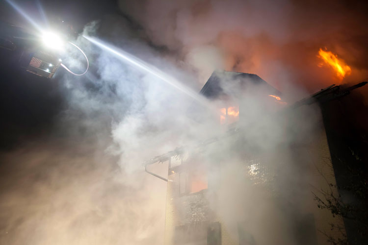 Flammen im Dachbereich werden gezielt bekämpft.