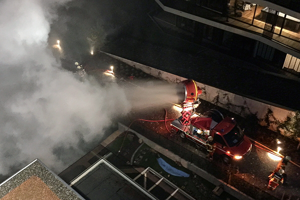 Mit Wassernebel aus dem Mobilen Grossventilator wird eine Hauswand gekühlt.