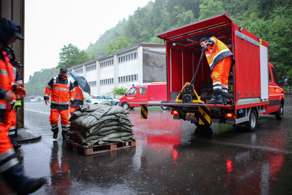 Feuerwehrleute bringen Sandsäcke an den Einsatzort.