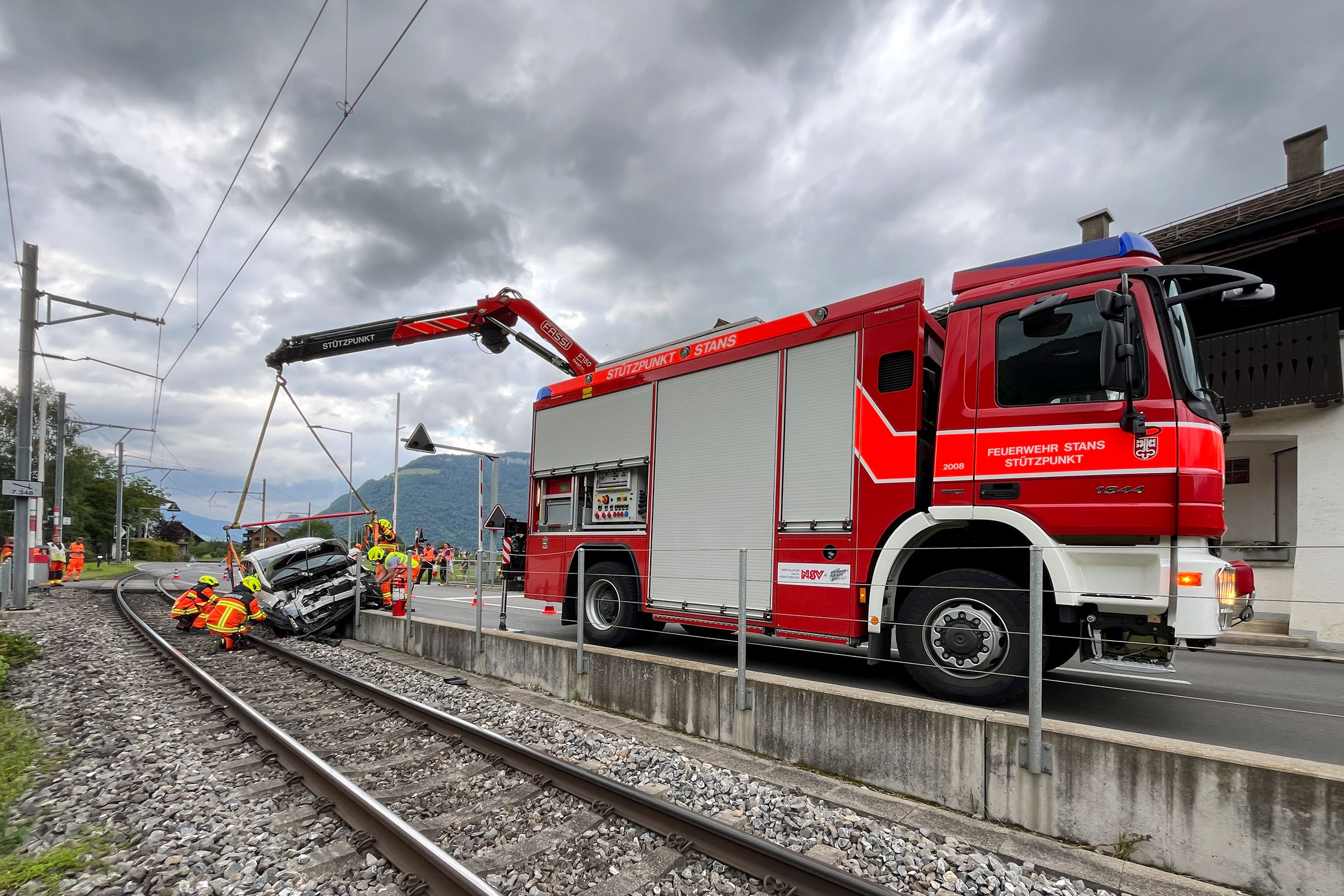 In Oberdorf gerät ein Auto auf das Trassee der Zentralbahn. Die Feuerwehr lässt die Fahrleitung ausschalten, erdet sie und holt das Unfallfahrzeug mit dem Kran von den Schienen.