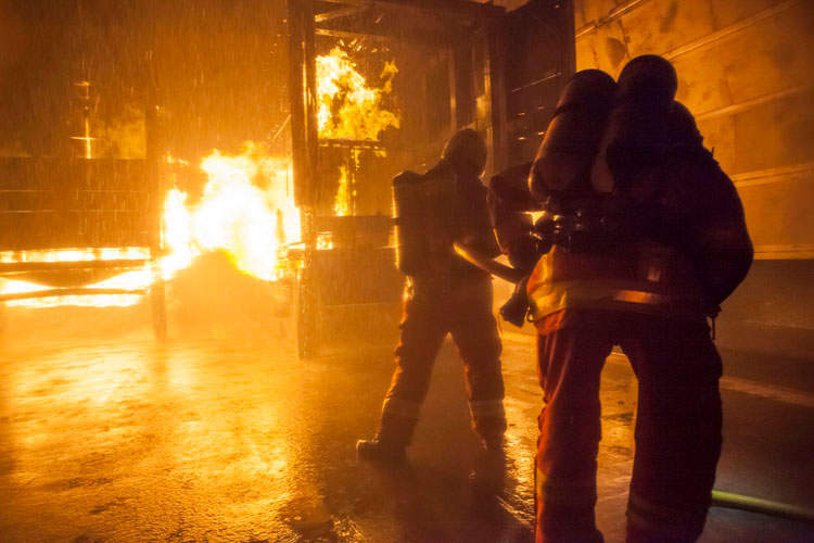 Ein Löschtrupp bekämpft das Feuer im Laderaum des Lastwagens.