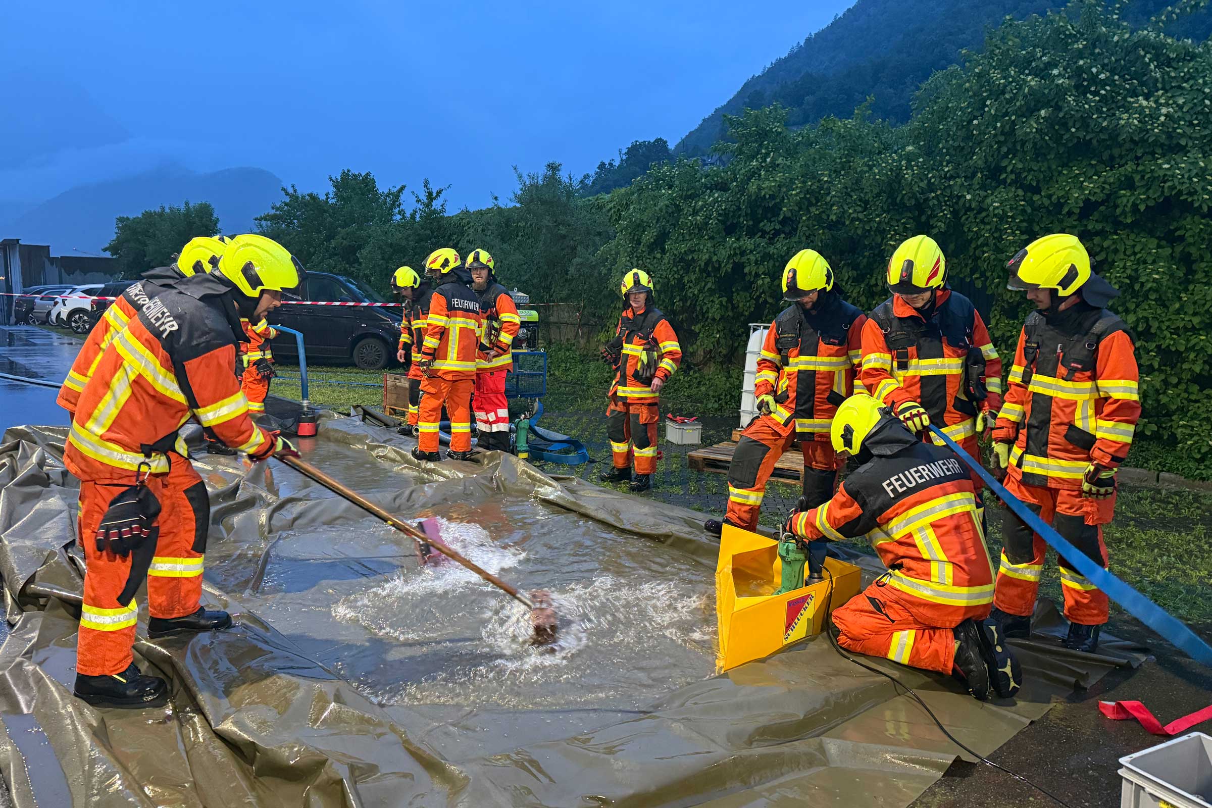 Hilfsmittel zum Abpumpen von Wasser werden hinter dem Feuerwehrlokal ausprobiert.