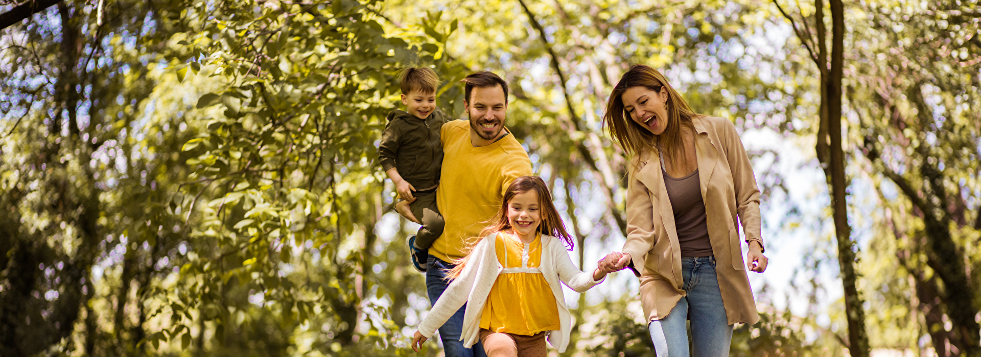 Eine Familie springt durch eine Waldlichtung.