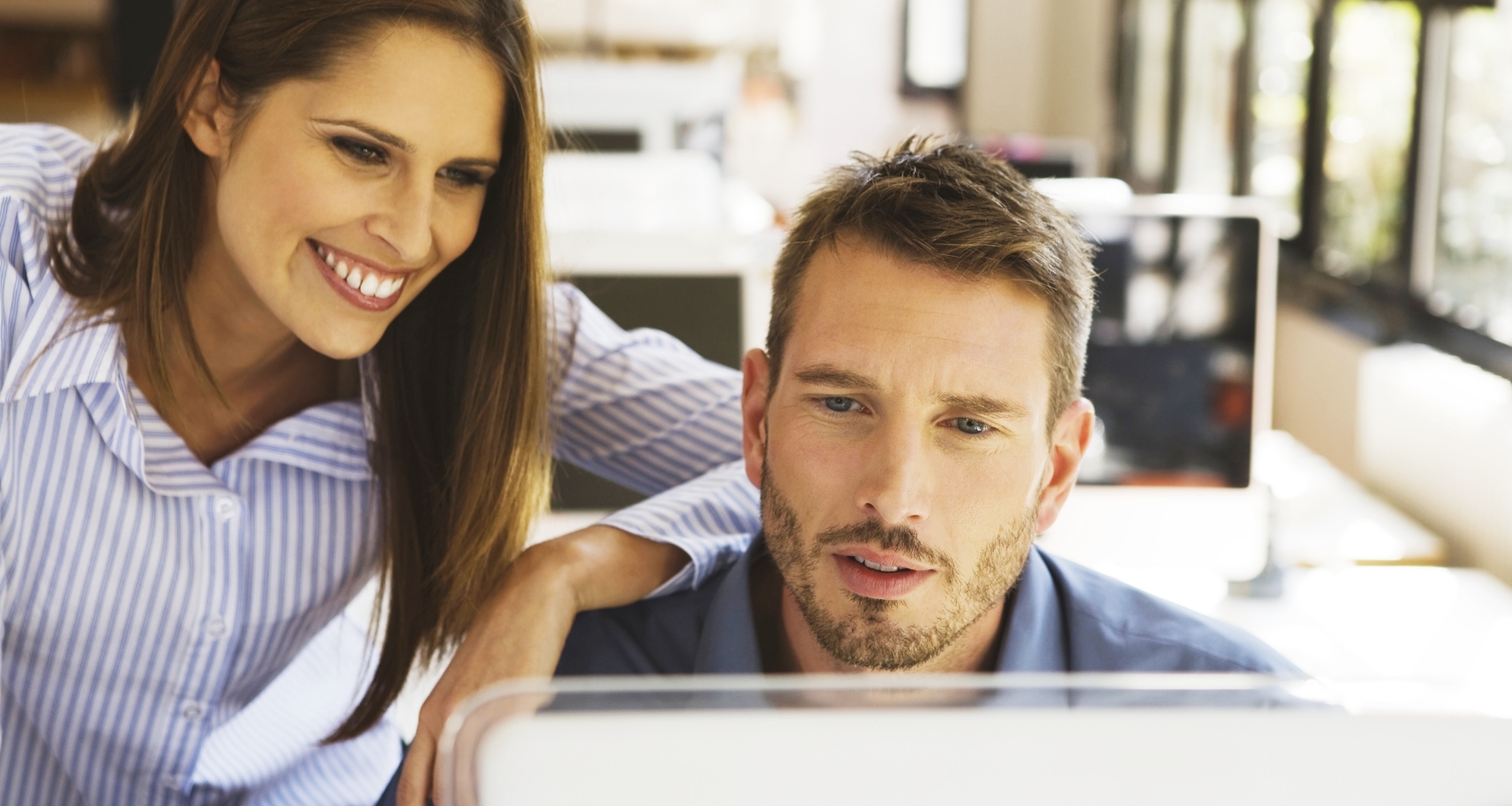 Un homme et une femme regardant un écran d'ordinateur.