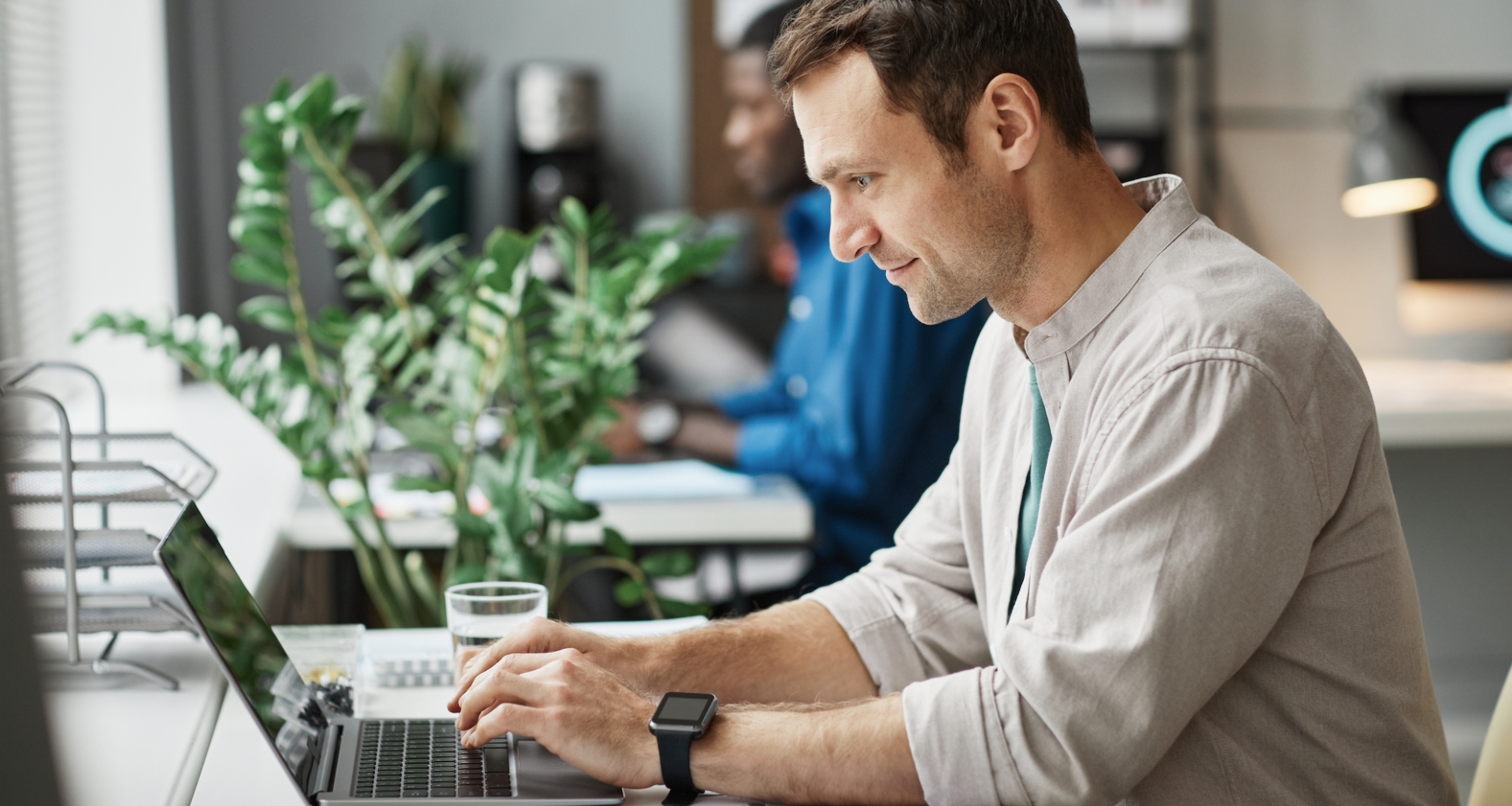 Homme travaillant sur son ordinateur portable, vu de profil