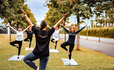 Eine Gruppe macht die Yoga-Übung, der sogenannte Baum, welche die Kursleiterin vorzeigt. Bild: Radix
