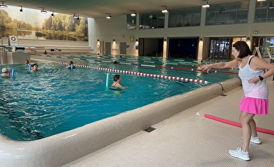 Die Aquafit-Kursleiterin zeigt vor, was die Teilnehmer/innen im Wasser tun sollen.