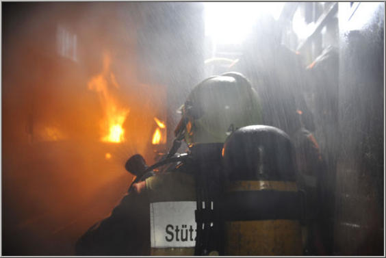 Atemschutztrupp mit Feuer im Hintergrund